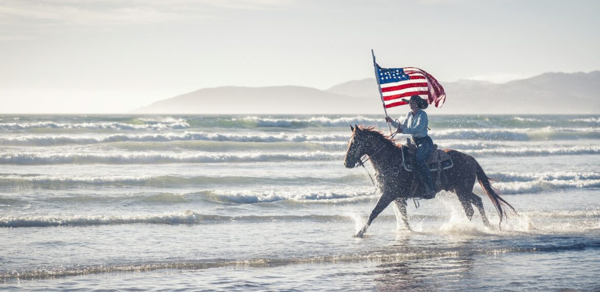 un-homme-montant-un-cheval-avec-un-drapeau-américain-sur-son-dos