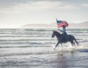 un-homme-montant-un-cheval-avec-un-drapeau-américain-sur-son-dos