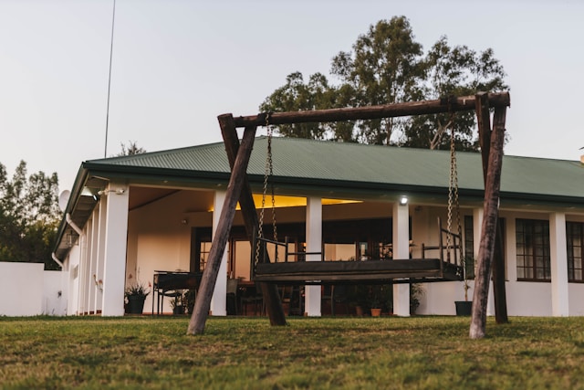 une balancoire devant une maison blanche